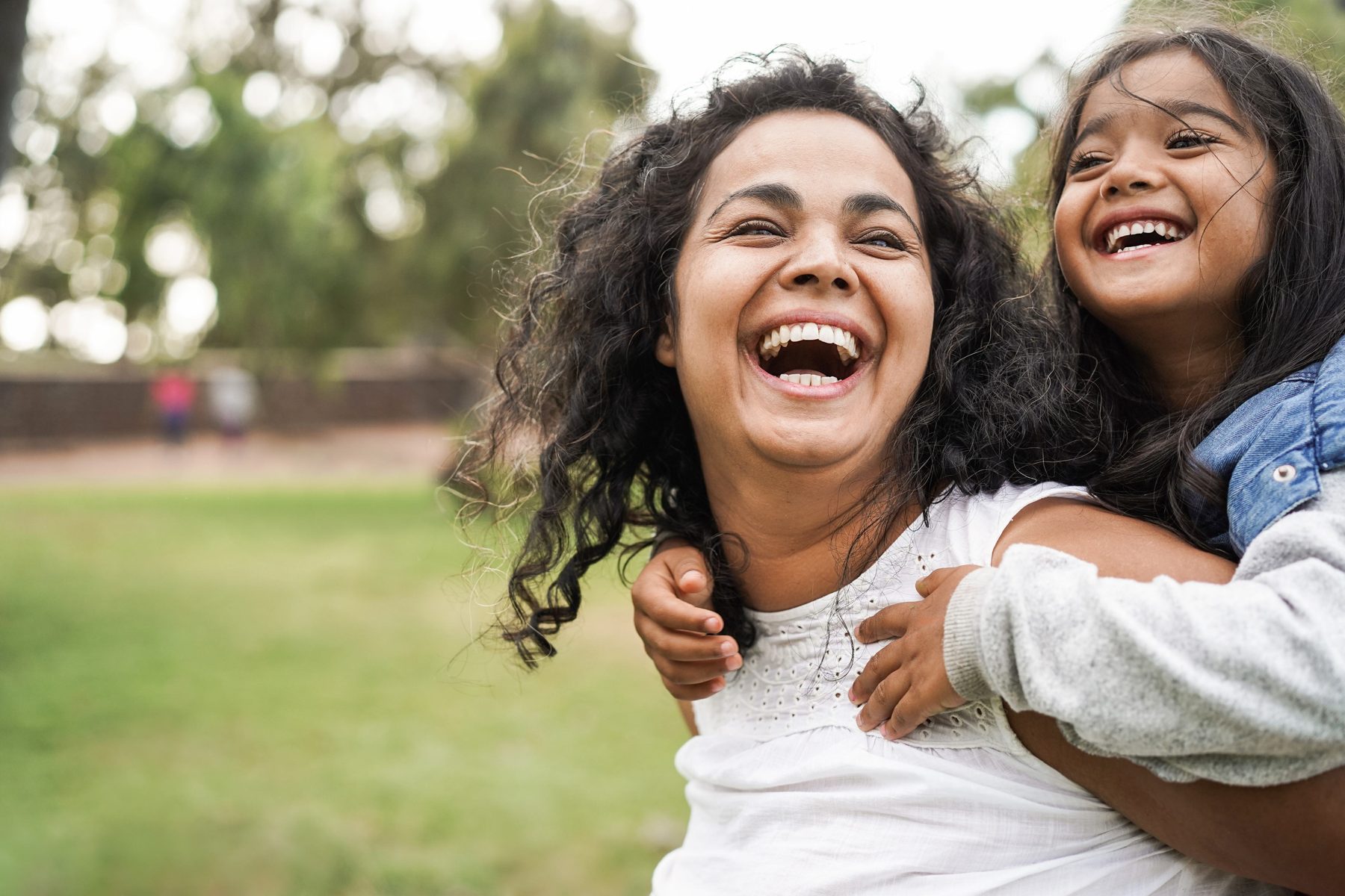 A parent and child smiling outdoors